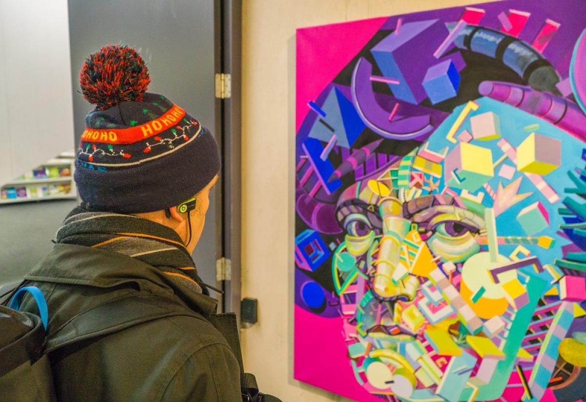 Man looking at a painting in a library exhibition space