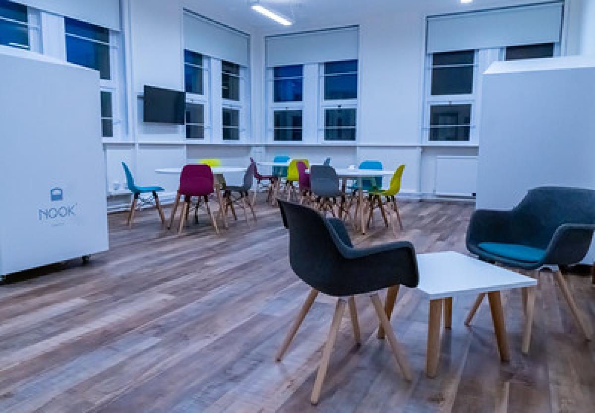 An empty chair stands in the middle of a library room