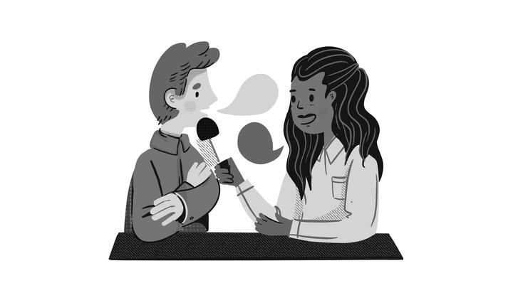 This is a grayscale illustration showing two people sitting at a table. One person, on the left, is speaking into a microphone held by the other person, on the right. The person on the left has short hair and is wearing a jacket. The person on the right has long hair and is wearing a collared shirt, smiling as they conduct what appears to be an interview. Both individuals have speech bubbles above their heads, indicating conversation or dialogue.