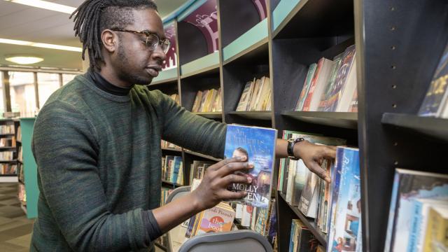 A library worker shelves books.