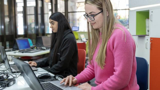 Two women working at computers in a library.