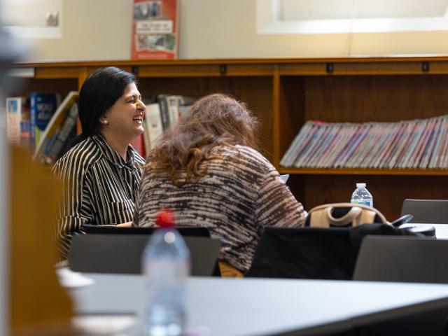 A woman laughts in a library.