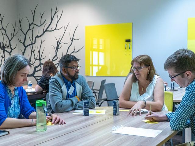 People sat talking at a table in a meeting room