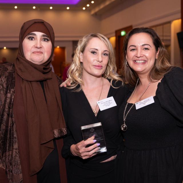 Three award winners smile at the camera.