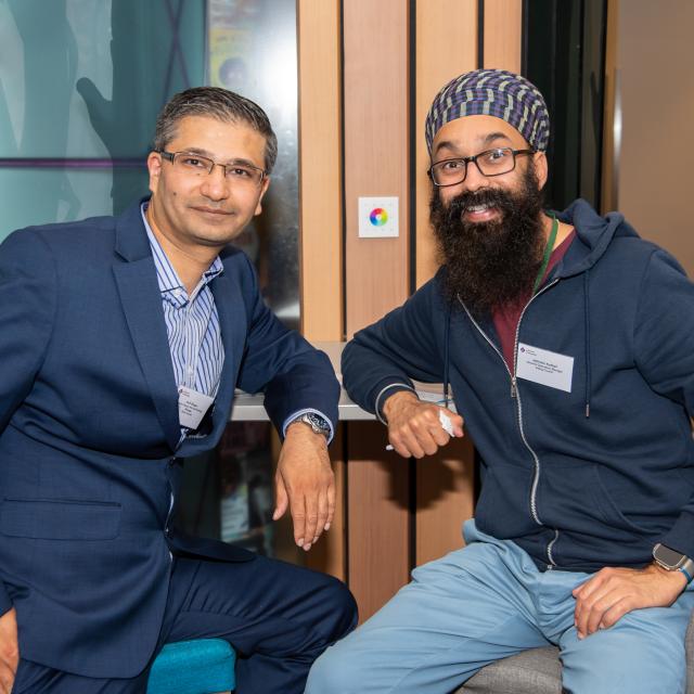 Two men smile at the camera.