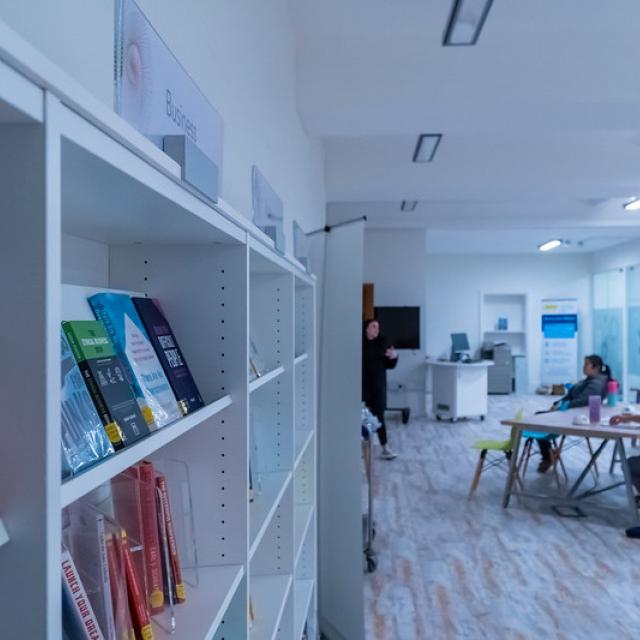 The inside of a library. People are sitting down in the background.