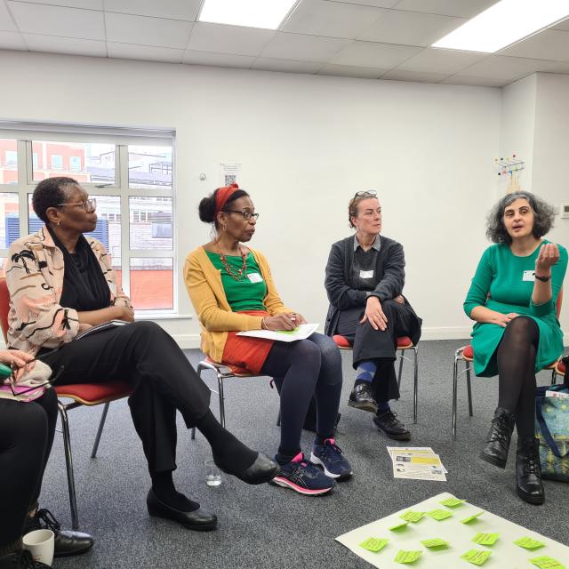 five people sat on chairs discussing ideas