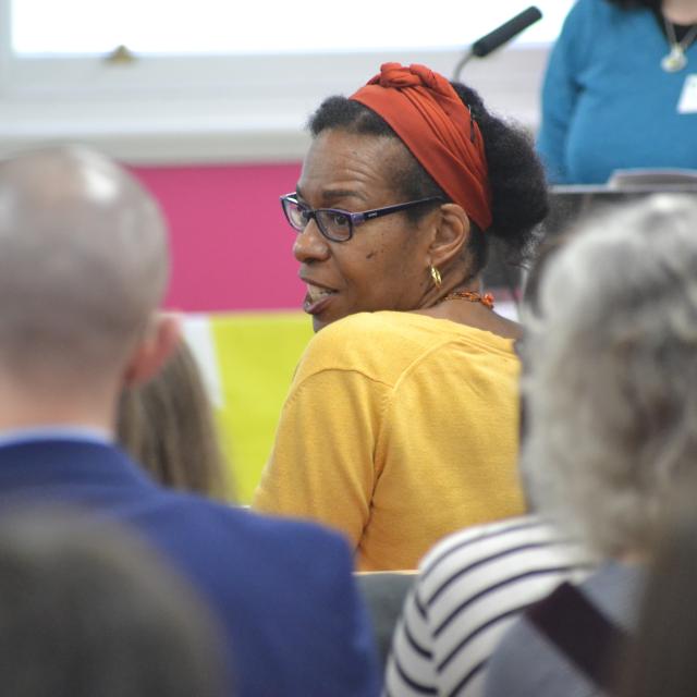 people sat in an audience with a woman glancing back