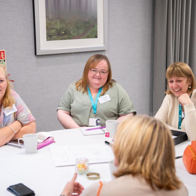 a group of women sat around a table discussing ideas